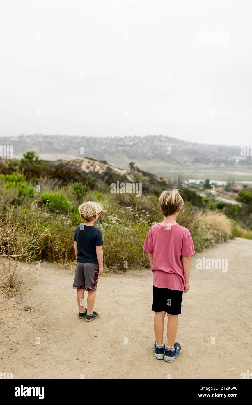 Two Brothers Standing at Top of Hill While Hiking in San Diego Stock Photo