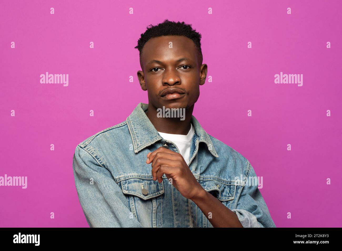 Portrait of young handsome African man model posing in purple color studio isolated background Stock Photo