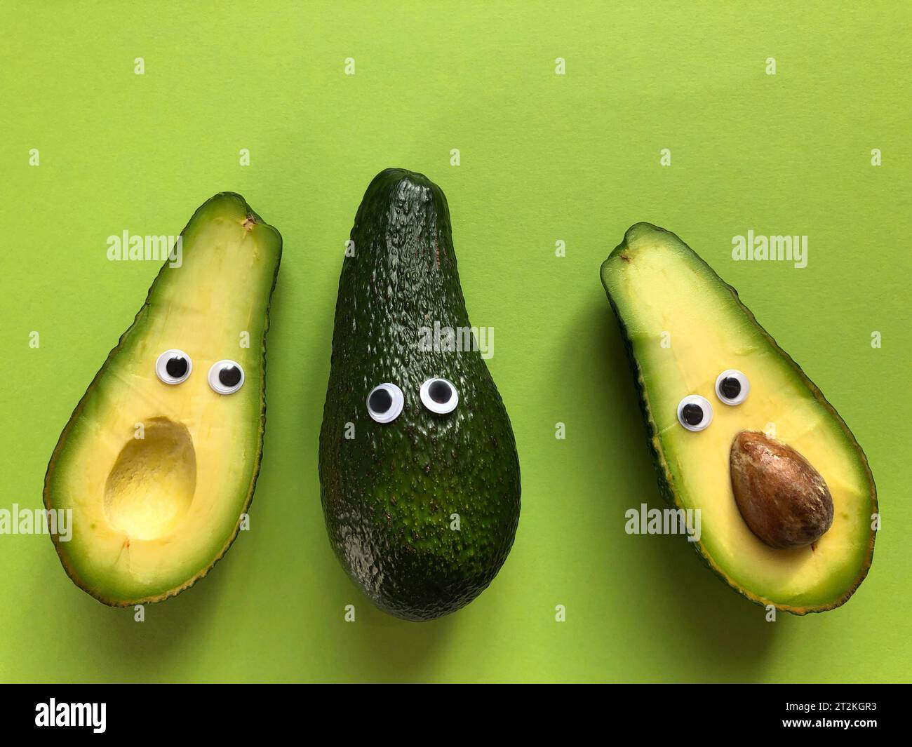 Creative healthy food concept. Avocados with googly eyes, whole and cut