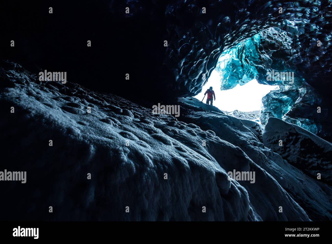 Adventurer discovering the inside of an ice cave in Iceland Stock Photo