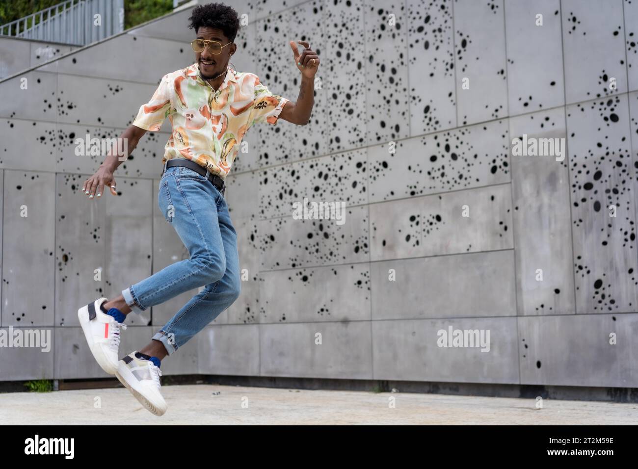 Horizontal photo with copy space of a stylish afro man jumping in the street Stock Photo