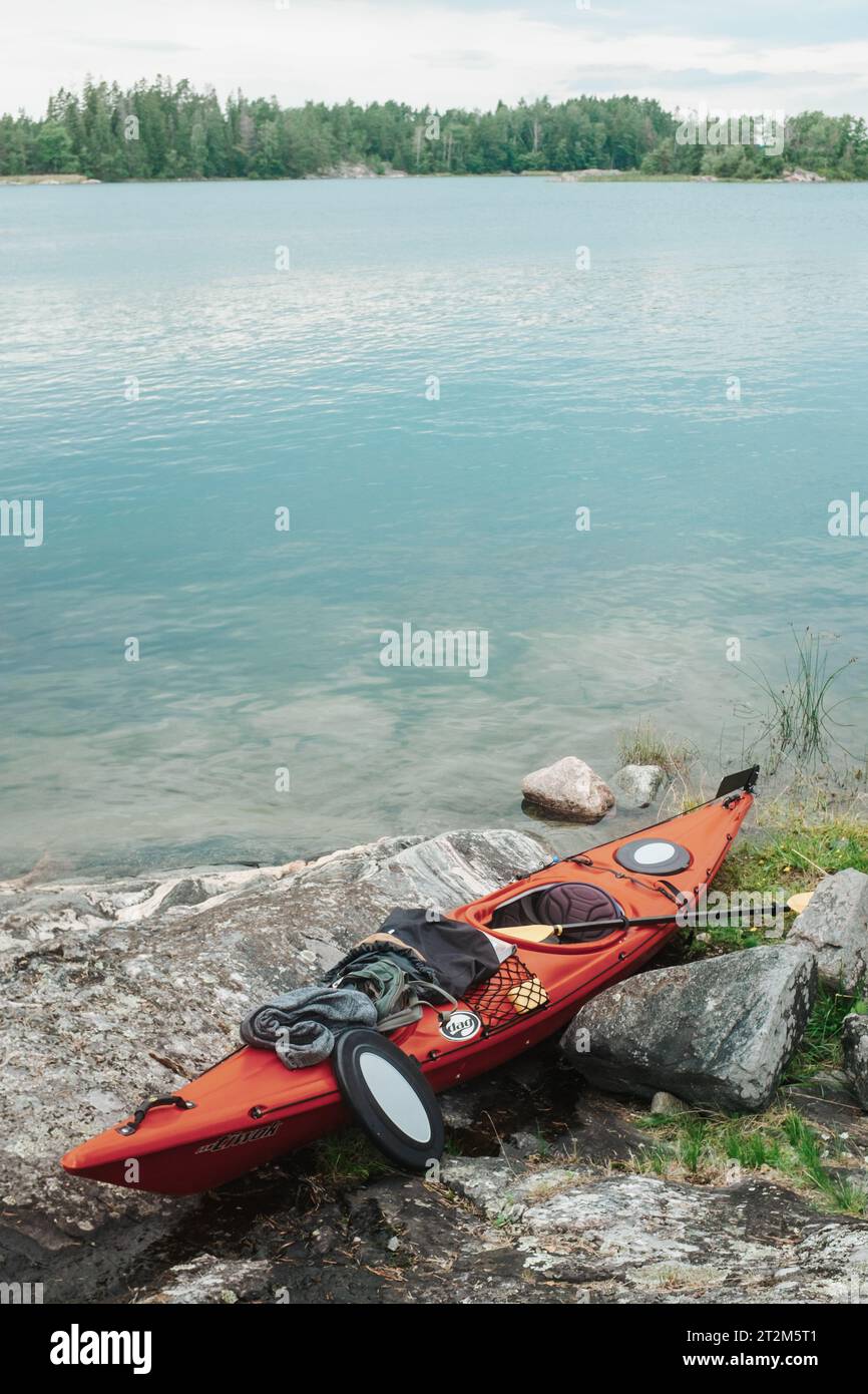 A lonely kayak sits by the shore as its driver takes a break. Stock Photo