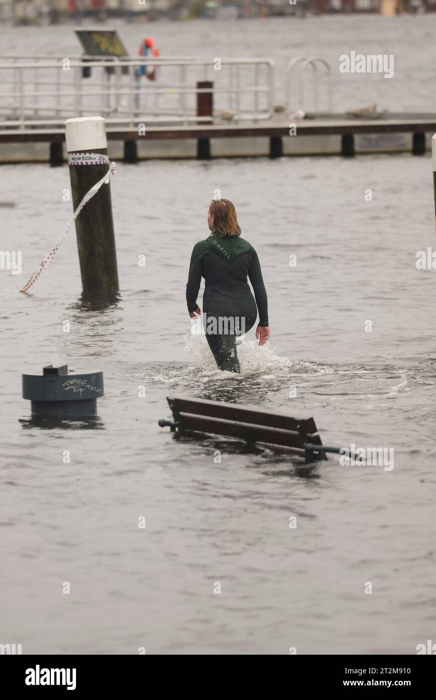 Flensburg, Germany. 20th Oct, 2023. A woman walks through the water in