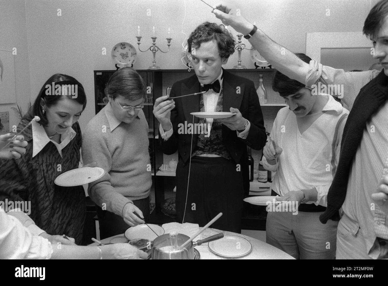 Cheese Fondue dinner party. Very popular amongst the aspiring suburban middle class of the 1980s. This group all went on to become successful lawyers, bankers and bursars. (The man in dinner jacket is Gerald Edgar Grimstone, Lord Grimstone of Boscobel, more commonly know as Gerry Grimstone) he is a British businessman. He was previously chairman of Barclays Bank plc and of Standard Life and group deputy chairman of Barclays plc, the holding company for the Barclays Group. Southfields, London, England  December 1980. UK HOMER SYKES Stock Photo