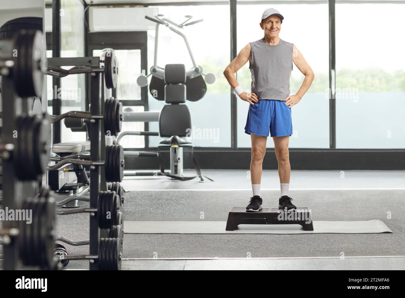 Full length portrait of an elderly man in sportswear standing on a step aerobic platform at a gym Stock Photo