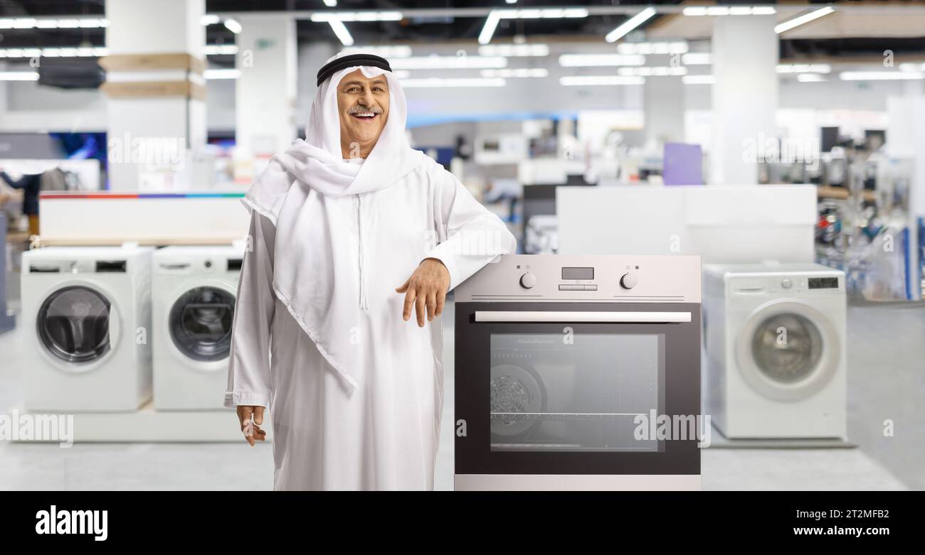 Mature arab man leaning on an oven at a shop Stock Photo