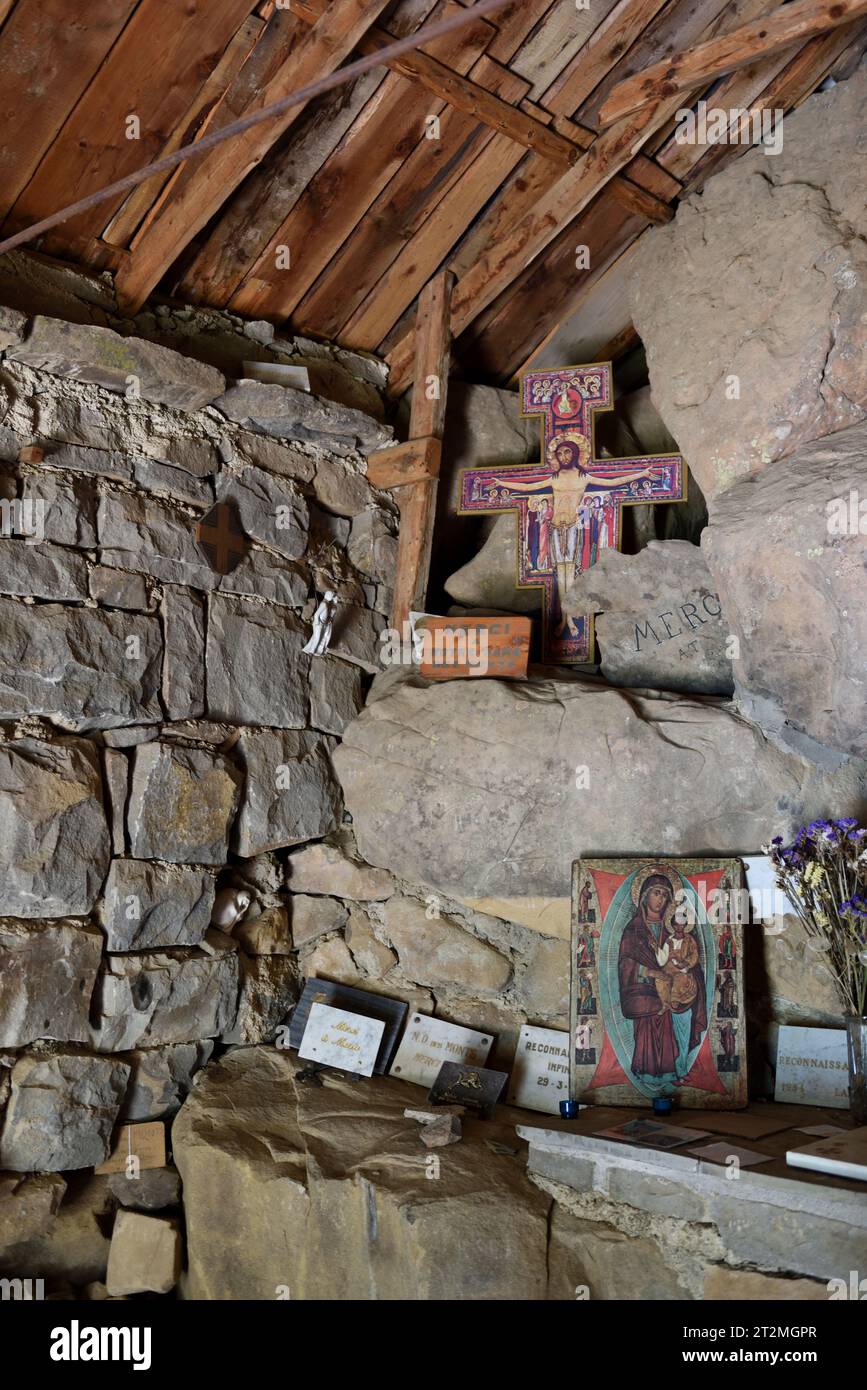 Interior, Rustic Altar & Christ on Cross in Semi-Troglodyte Chapel of Notre Dame des Monts Allos Alpes-de-Haute-Provence Provence France Stock Photo