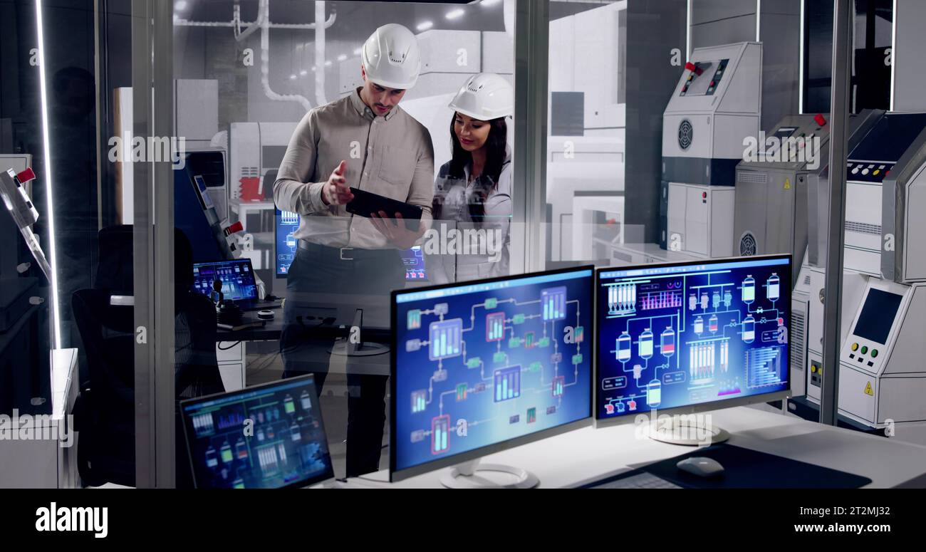 Factory Engineers In Helmets. Checking Industrial Facility Stock Photo