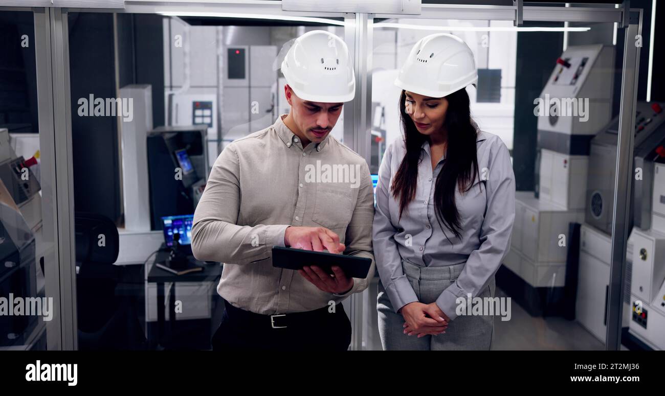 Factory Engineers In Helmets. Checking Industrial Facility Stock Photo