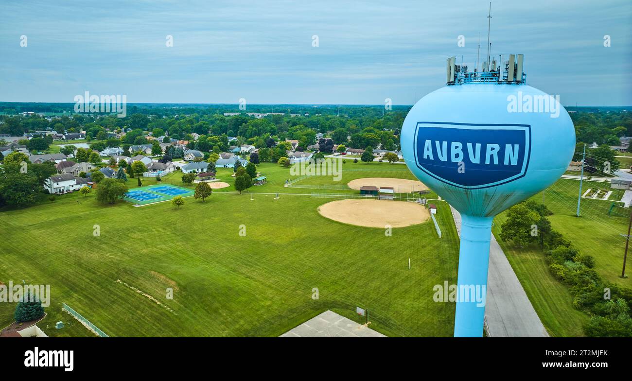 Aerial of curved Auburn water tower with distant houses and