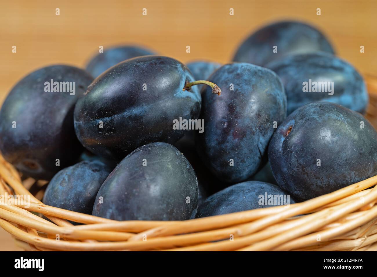 Ripe house plums in basket Stock Photo