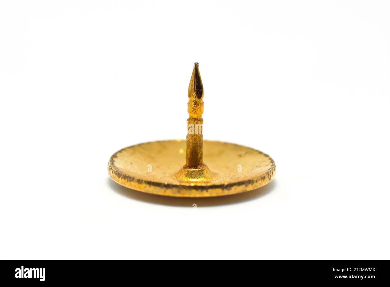 Close up of a single brass drawing pin, push pin or thumb tack, isolated against a white background. Stock Photo