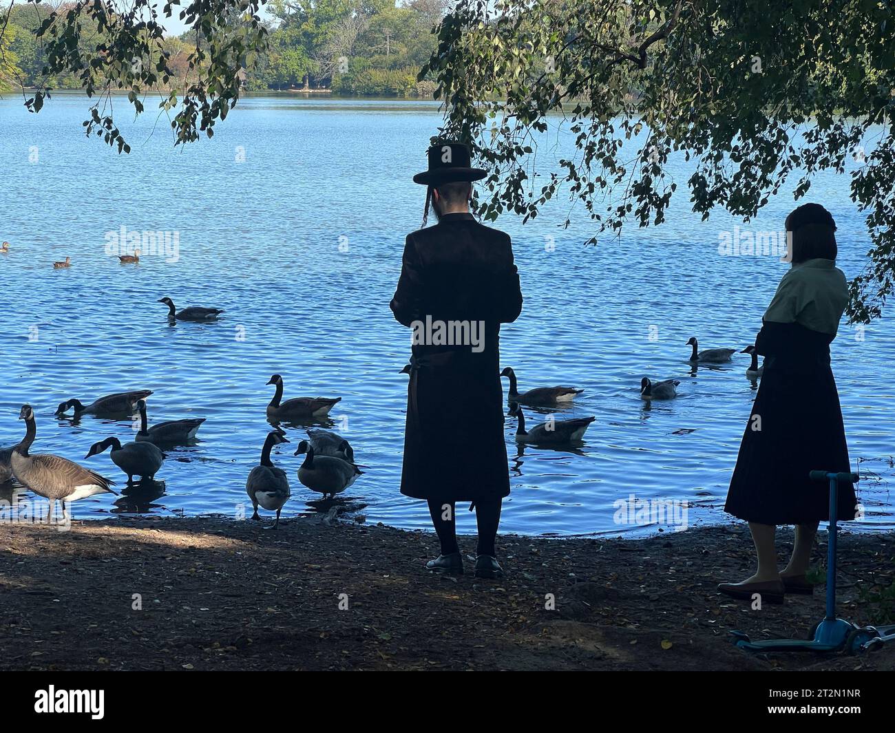 Orthodox Jewish couple saying prayers during Sukkot at the lake in Prospect Park, Brooklyn, New York. Stock Photo