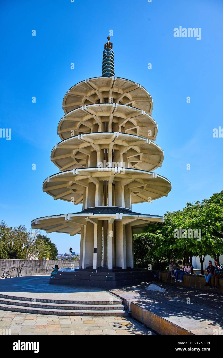 People sitting in shade under Peace Pagoda in Japantown on bright summer day with clear blue sky Stock Photo