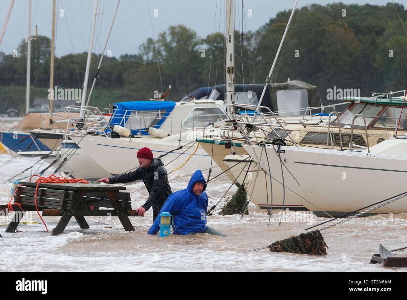 Two men attempting to secure a boat. The water is high in Hejlsminde on