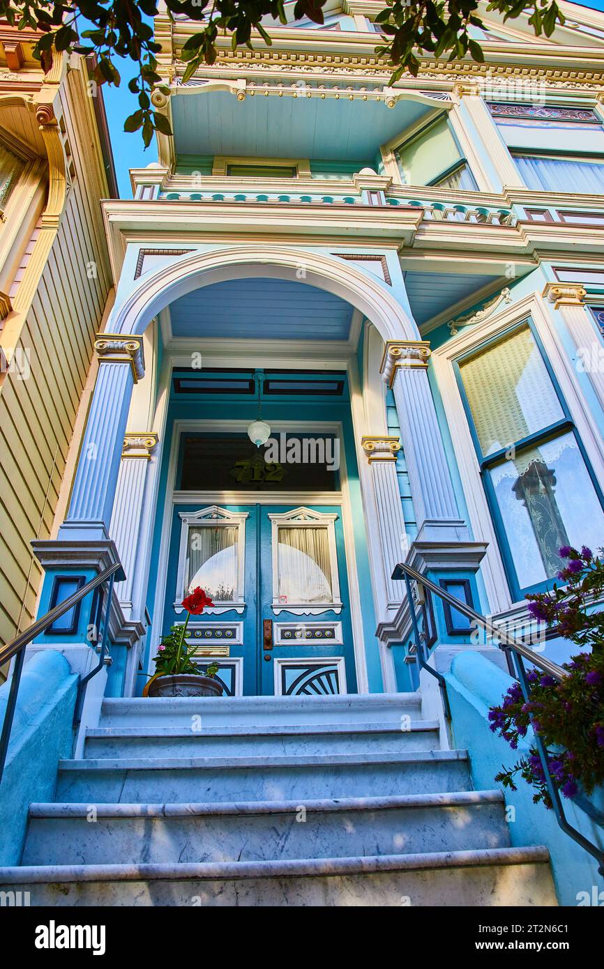 Sky blue house of The Painted Ladies entrance with red flower and 712 above Victorian doors Stock Photo