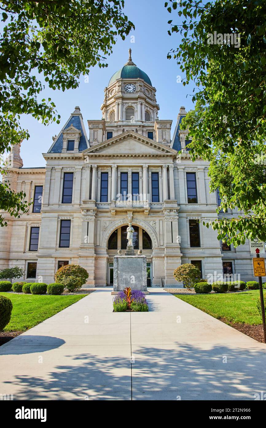 Statue in front of Whitley County Courthouse with flowers and front