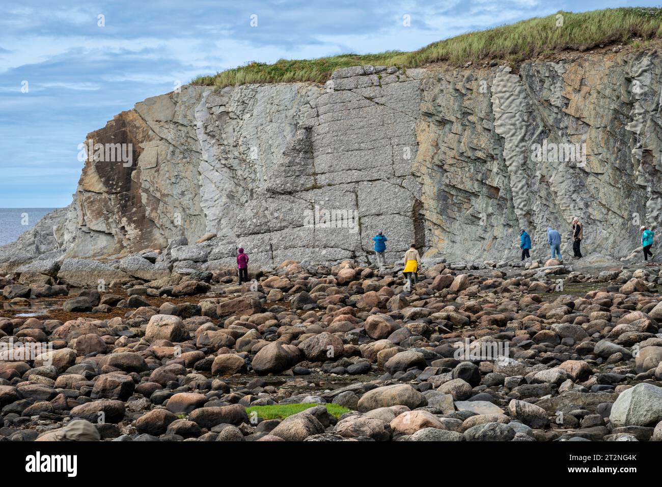 Tourists at Green Point in Gros Morne NP in Newfoundland, Canada, check geologic striations. Stock Photo