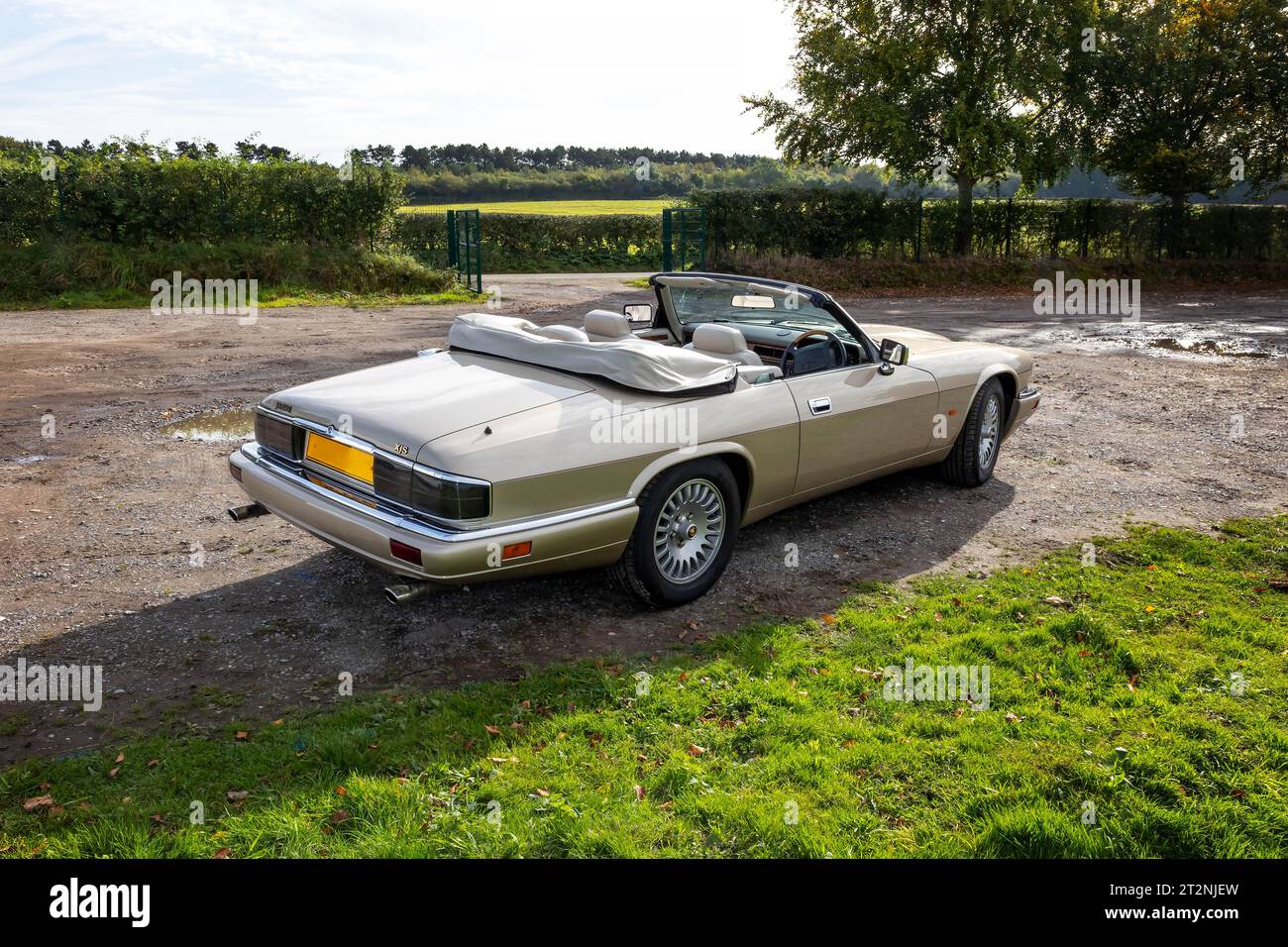 Rear view of convertible Jaguar XJS with top down on a gravel car park in the country Stock Photo