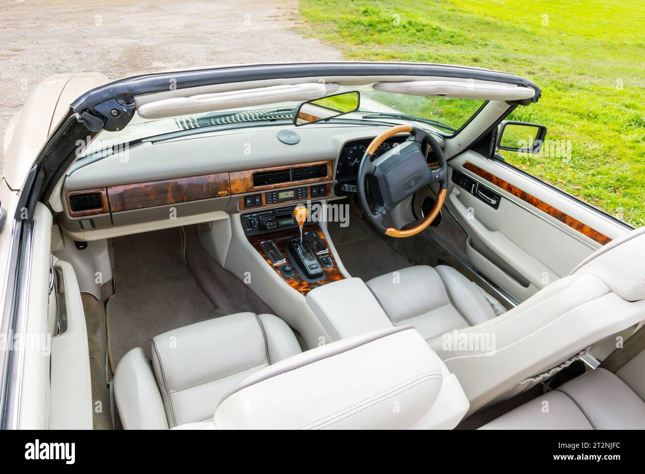 Cockpit of a convertible Jaguar XJS with top down on a gravel car park in the country Stock Photo