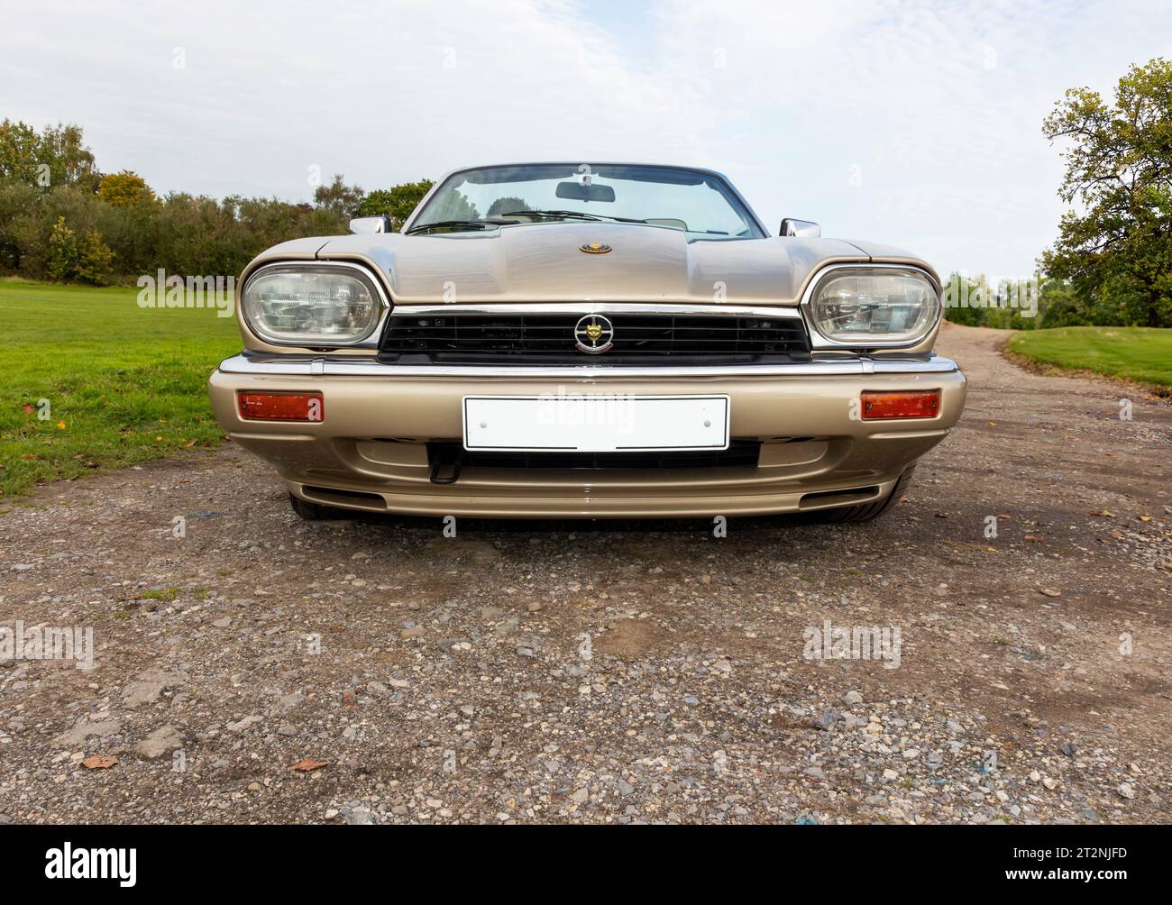 Low viewpoint of the front of a convertible Jaguar XJS with top down on a gravel car park in the country Stock Photo