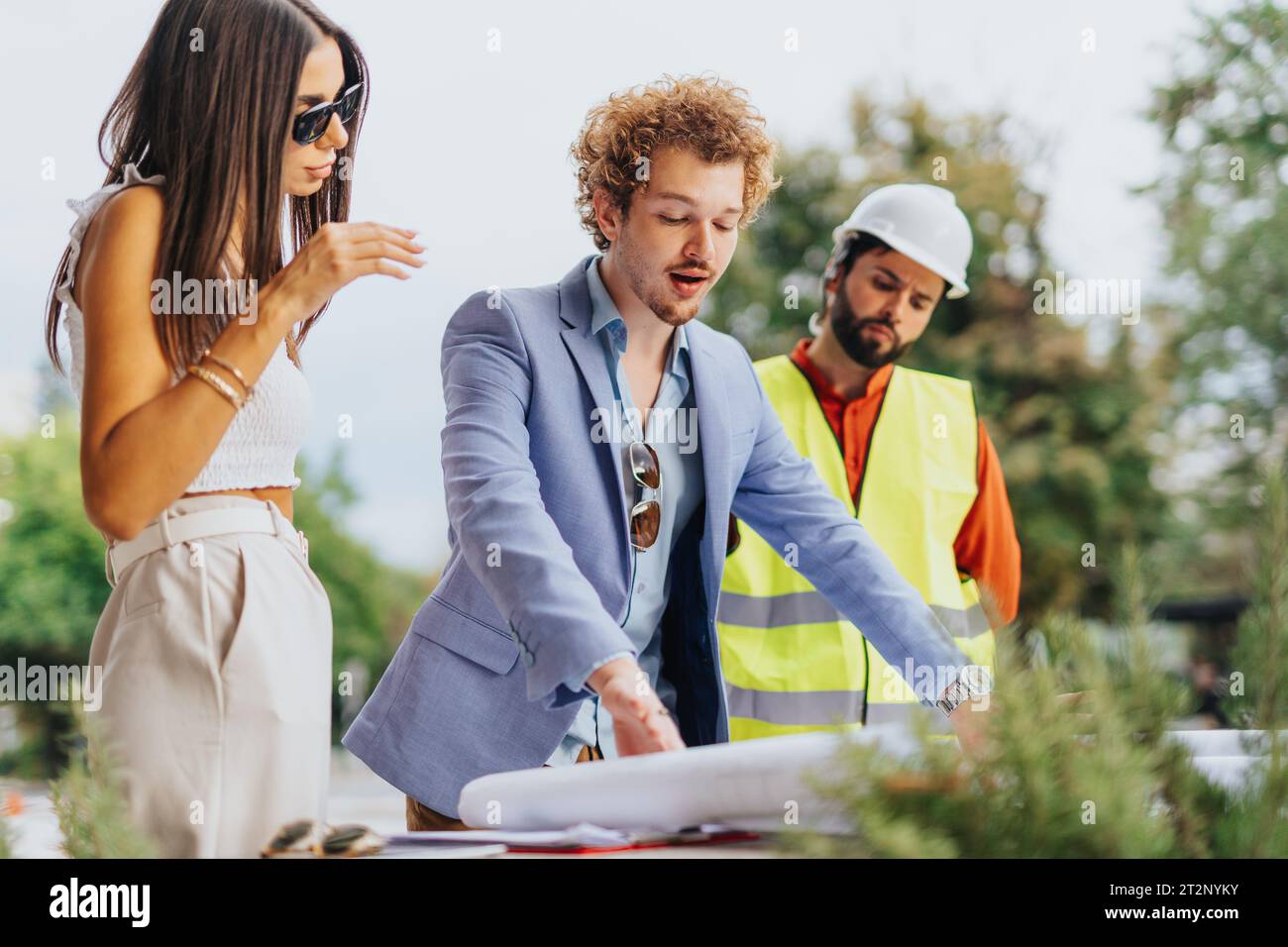 Architects discussing project costs and paperwork outdoors, analyzing ...