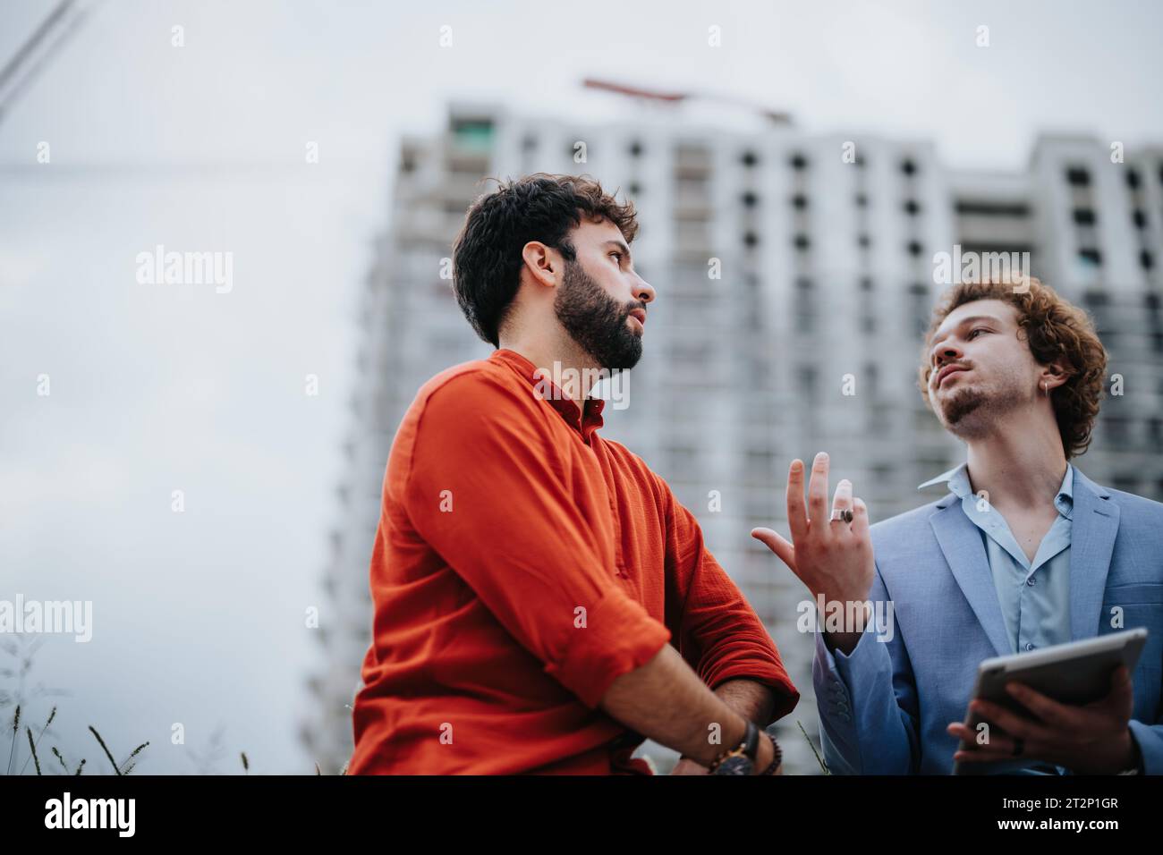 Architectural Team Discussing Project Details and Documents at Construction Site Stock Photo