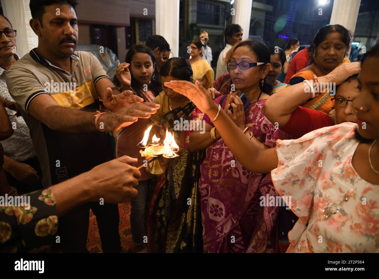 Kolkata, West Bengal, India. 20th Oct, 2023. Evening rituals of annual multi-day community worship of Hindu Goddess Durga where Hindu devotees taking heat from the Pancha Pradip as blessings on the auspicious Shashthi Tithi. The Durga puja in autumn is the biggest multi-day annual Hindu festival of northeastern India. (Credit Image: © Biswarup Ganguly/Pacific Press via ZUMA Press Wire) EDITORIAL USAGE ONLY! Not for Commercial USAGE! Stock Photo