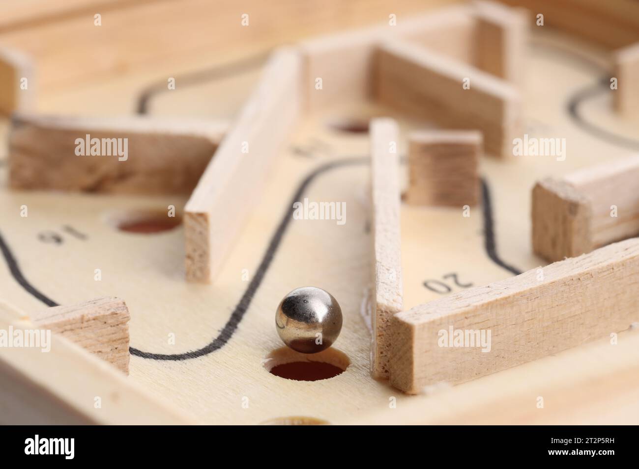 Wooden toy maze with metal ball, closeup Stock Photo