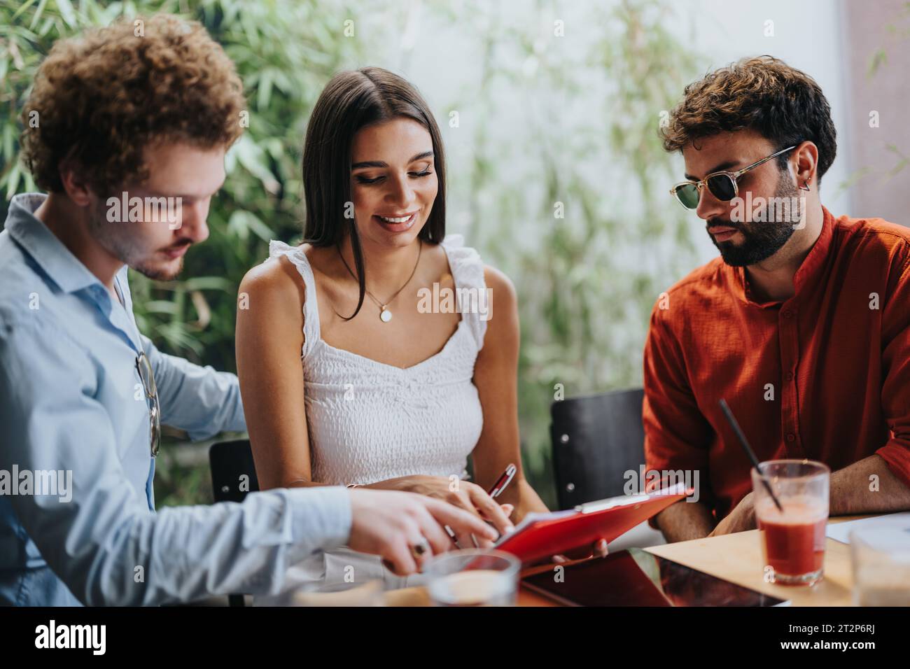 Collaborative Architects and Engineers Discussing Blueprint at Coffee Bar Stock Photo