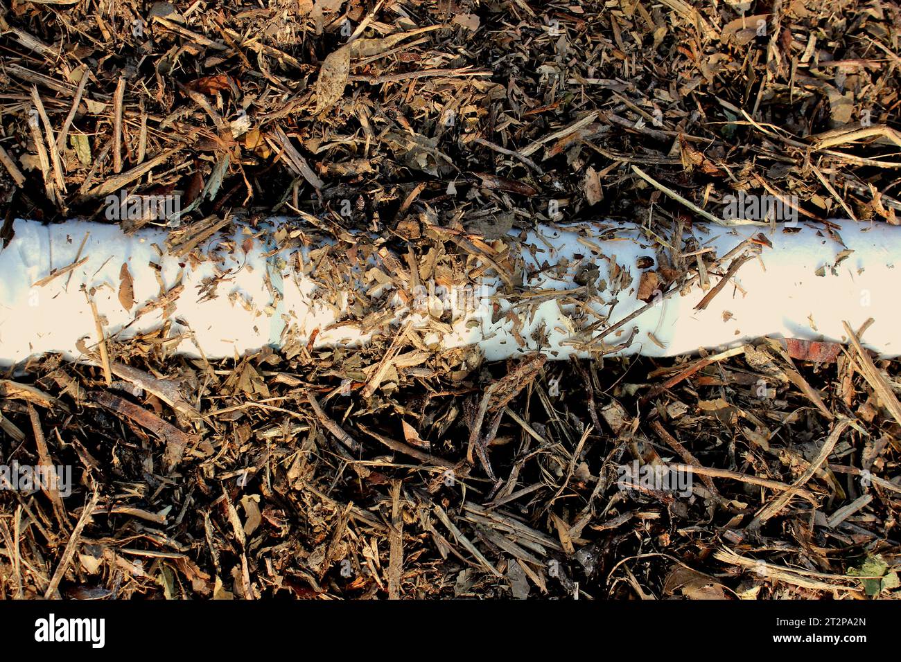 View of the drainage pipe of a composting windrow under construction, to collect the slurry