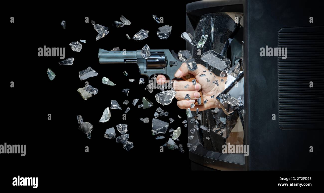 A hand with a gun smashes the CRT screen from inside the television Stock Photo