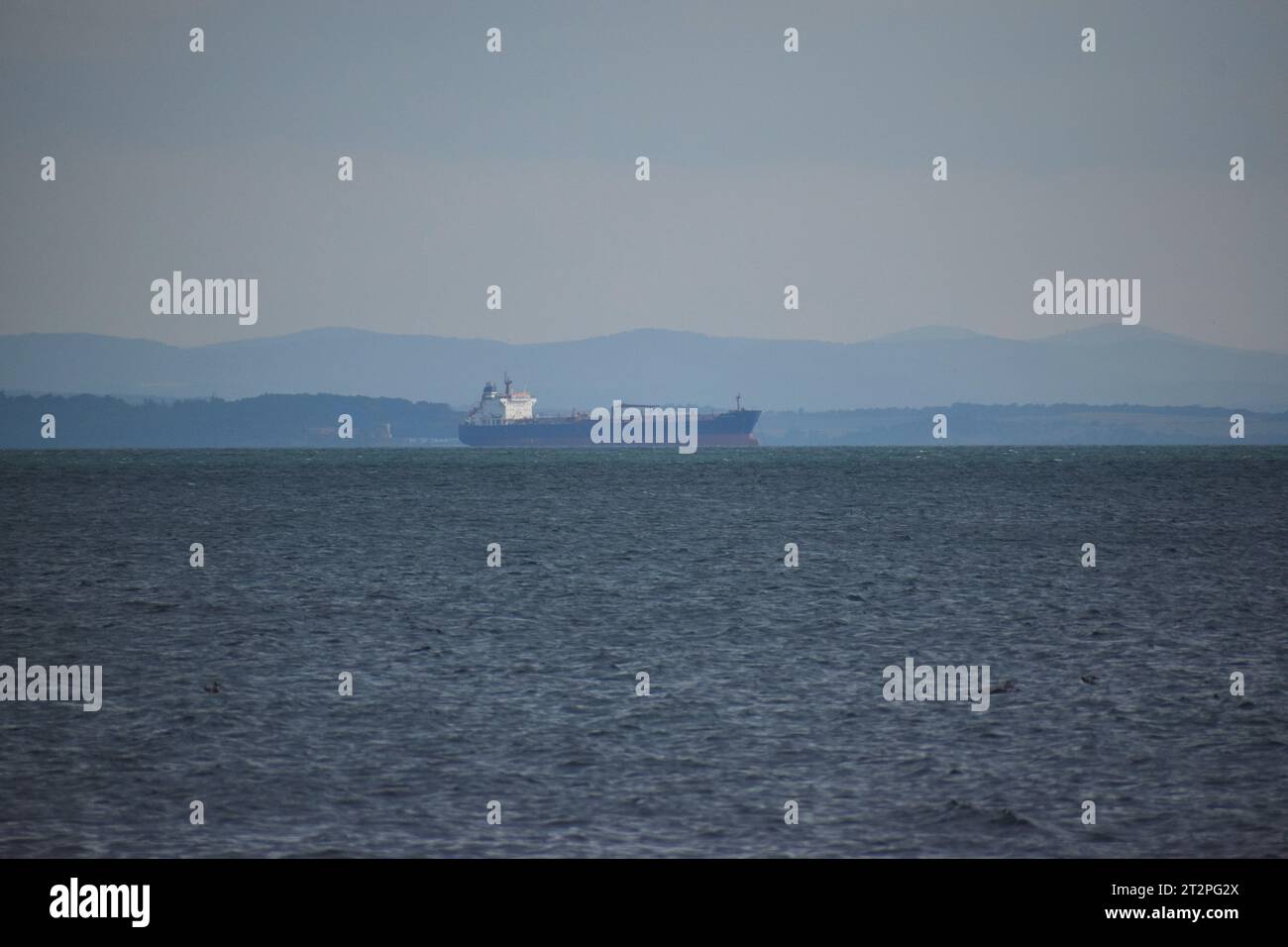 A boat sails across a calm, cloud-filled sea horizon Stock Photo - Alamy