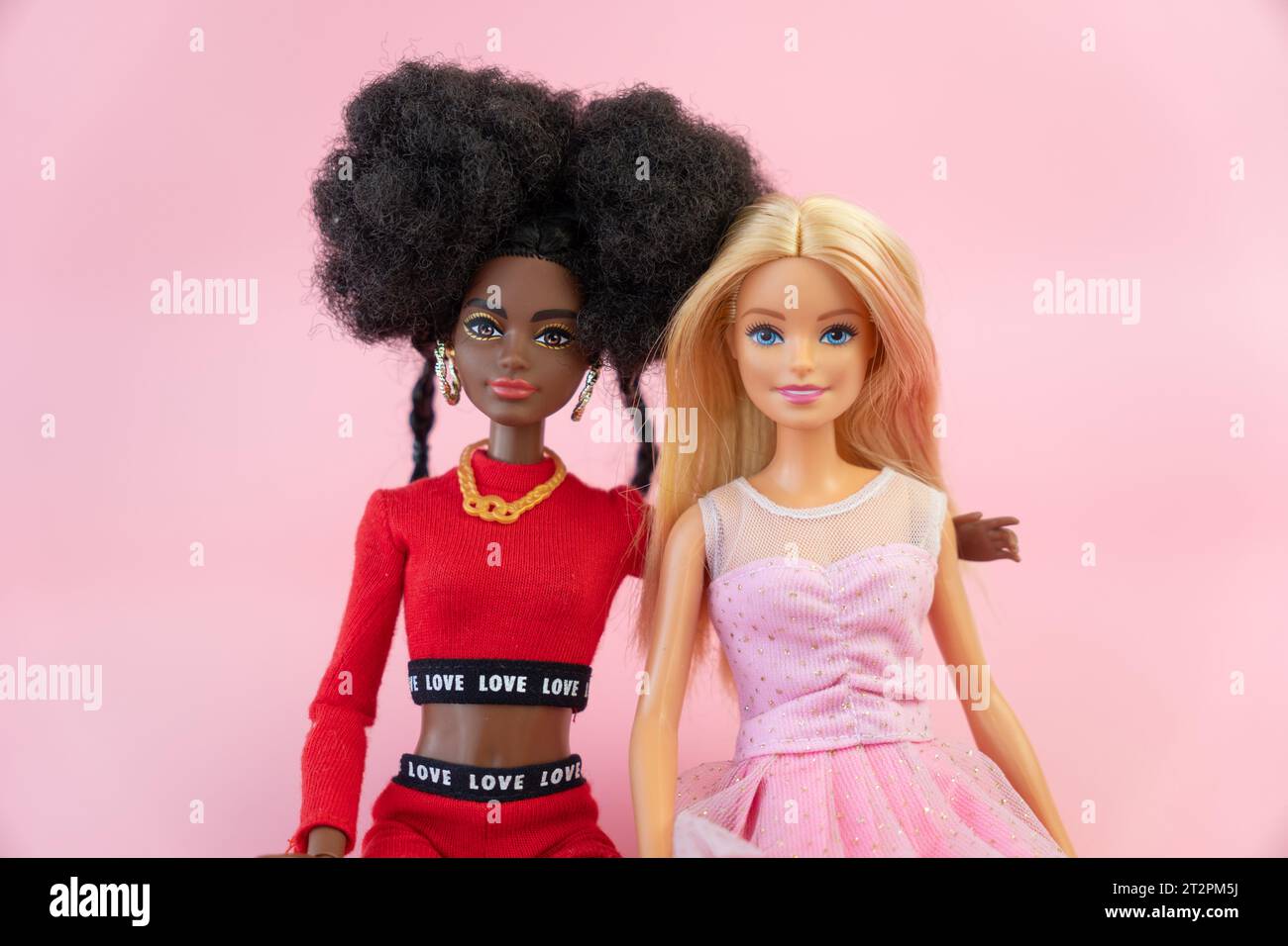 October 9, 2023. Barnaul, Russia: two dolls, a blonde barbie and her African-American friend on a pink background. Stock Photo