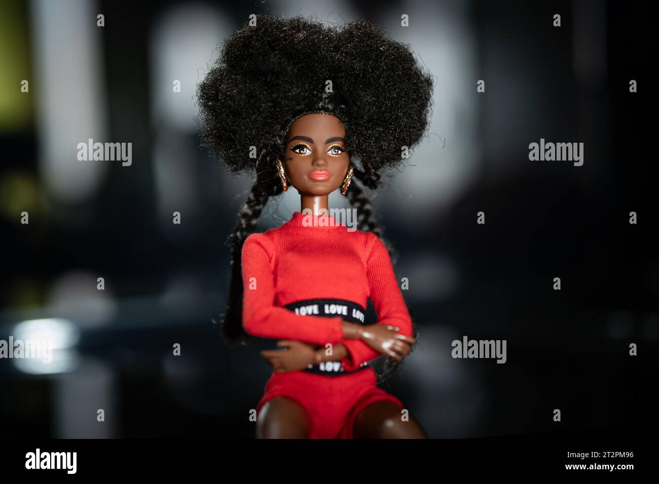 October 9, 2023. Barnaul, Russia: african american Barbie doll with black hair in a red suit standing on a dark background. Stock Photo