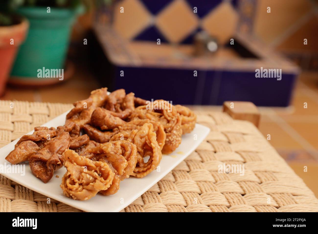 Moroccan chebakias on a white plate in a patio with plants Stock Photo ...