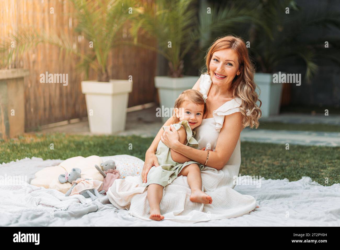 Mother and daughter enjoying a sunny weather in the garden. Copy space Stock Photo