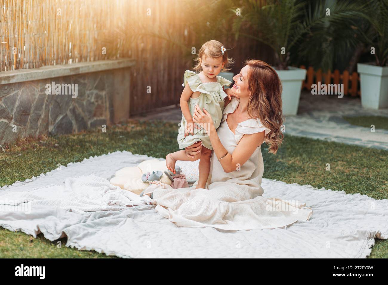 Mother and daughter enjoying a sunny weather in the garden. Copy space Stock Photo