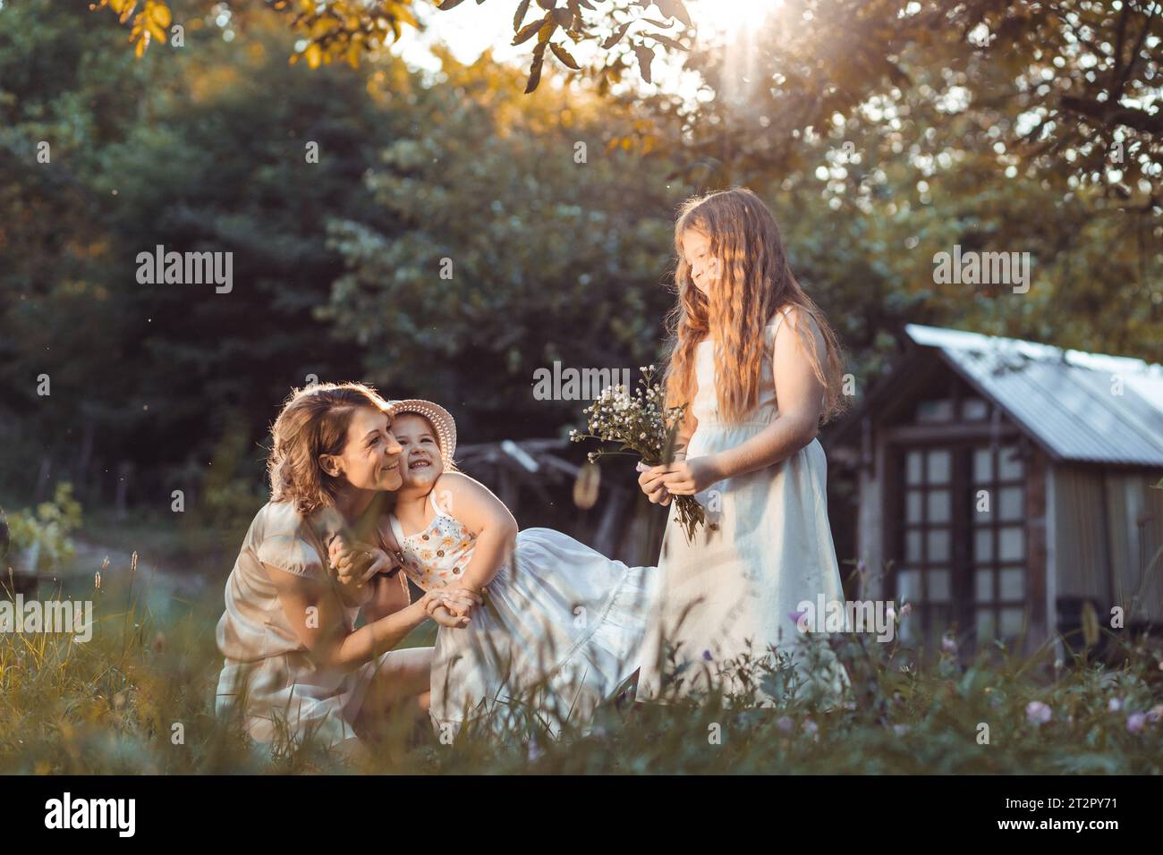 Mother and daughters enjoying a sunny weather in nature Stock Photo
