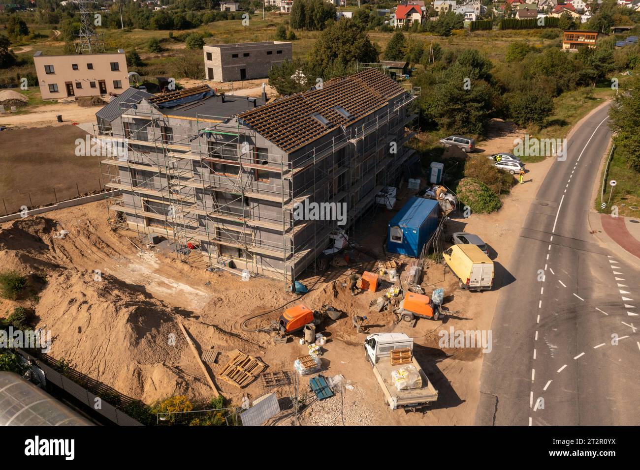 Drone photography of new residential house construction site, scaffolding and roofing during sunny autumn day Stock Photo