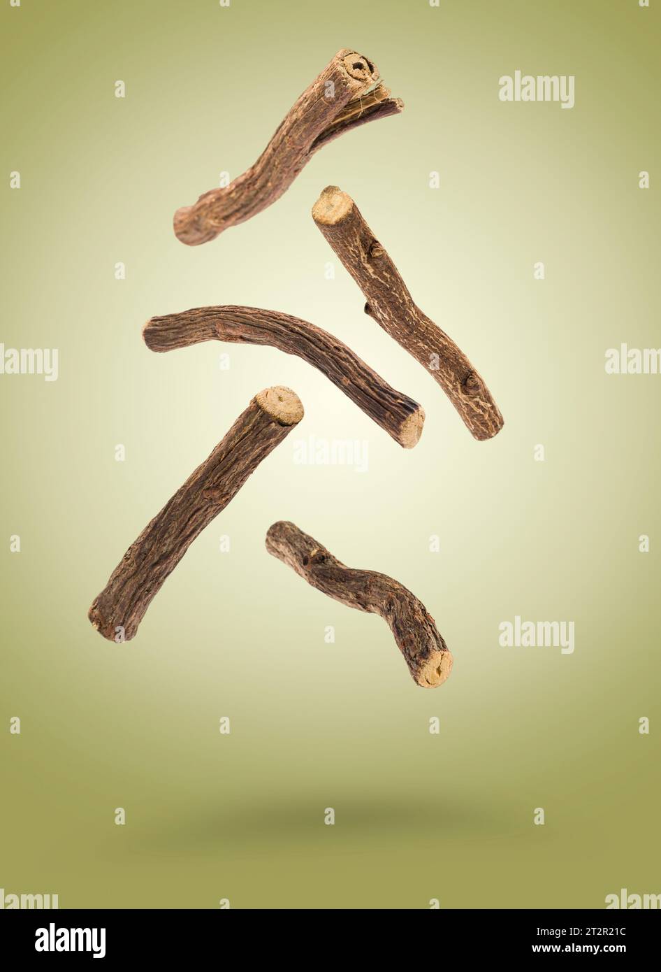 Sticks of liquorice root floating on green background. Stock Photo