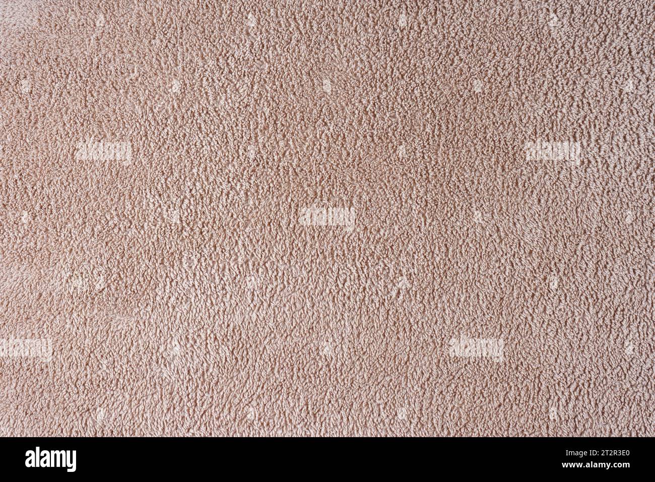 Terry cloth, beige towel texture background. Soft fluffy textile bath or beach towel material. Top view, close up. Stock Photo