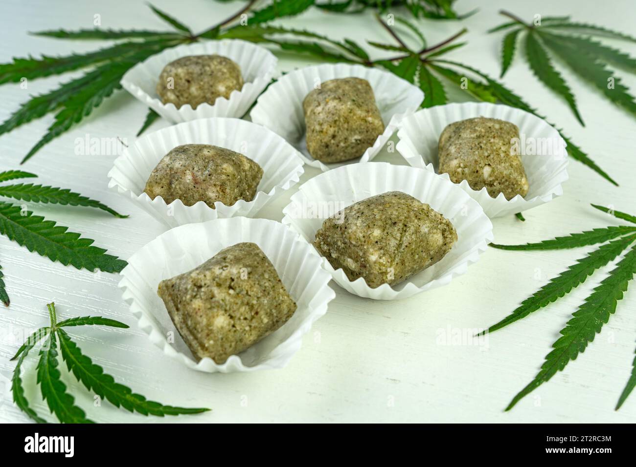Homemade candy with hemp seeds and dates. Healthy vegan food on the blue table. a narcotic product. Legalization of light drugs Stock Photo