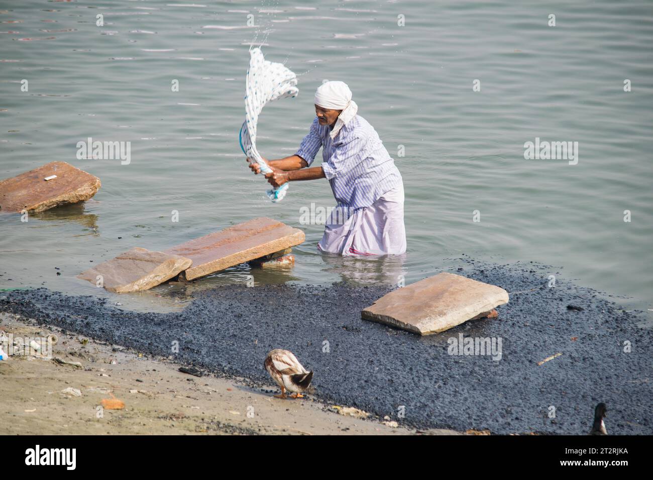 Man washing clothes at Ganges river in Varanasi Stock Photo - Alamy