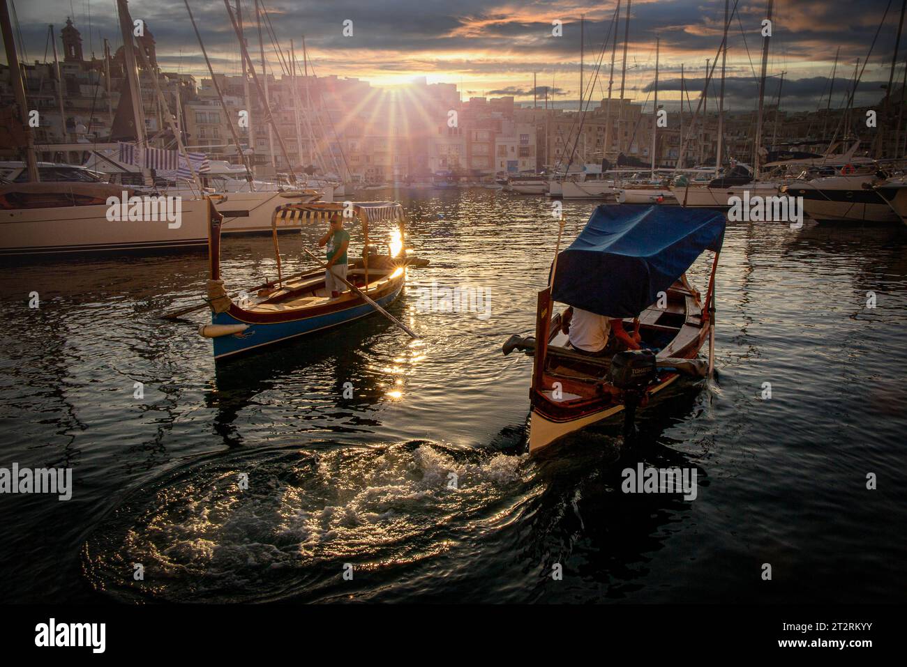 The Maltese Dghajsa (similar to a gondola) transports passengers between Valletta and Birgu in Malta as the sun sets Stock Photo