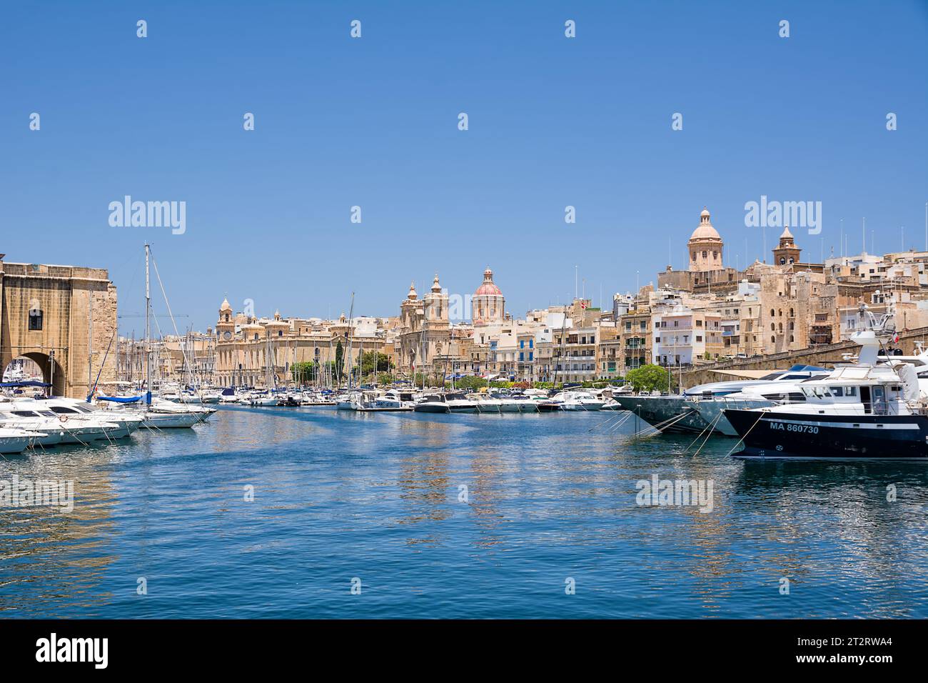 Vittoriosa, Malta - 17 June 2023: canal between Birgu and Senglea with the harbor and the Collegiate Church of Saint Lawrence Stock Photo
