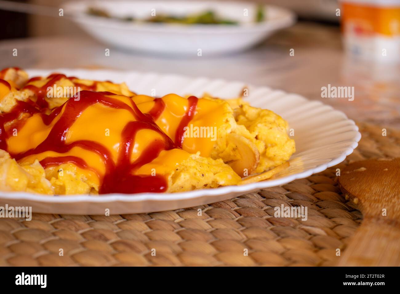 Egg and cheese with ketchup topping beside it some avocado Stock Photo