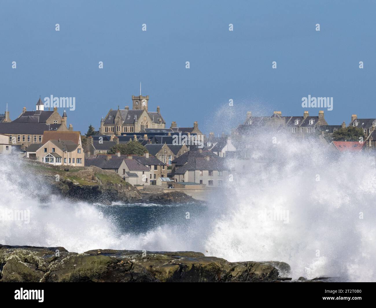 View of Lerwick, with Lerwick Town Hall at Hill Head, and crashing waves in Brei Wick, looking north from Seafield, Mainland Shetland, Scotland Stock Photo