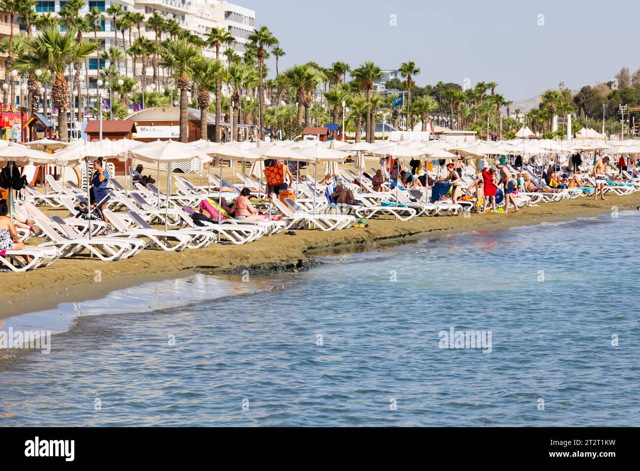 Tourists sunbathing and swimming on Finikoudes beach, Larnaca, Cyprus Stock Photo