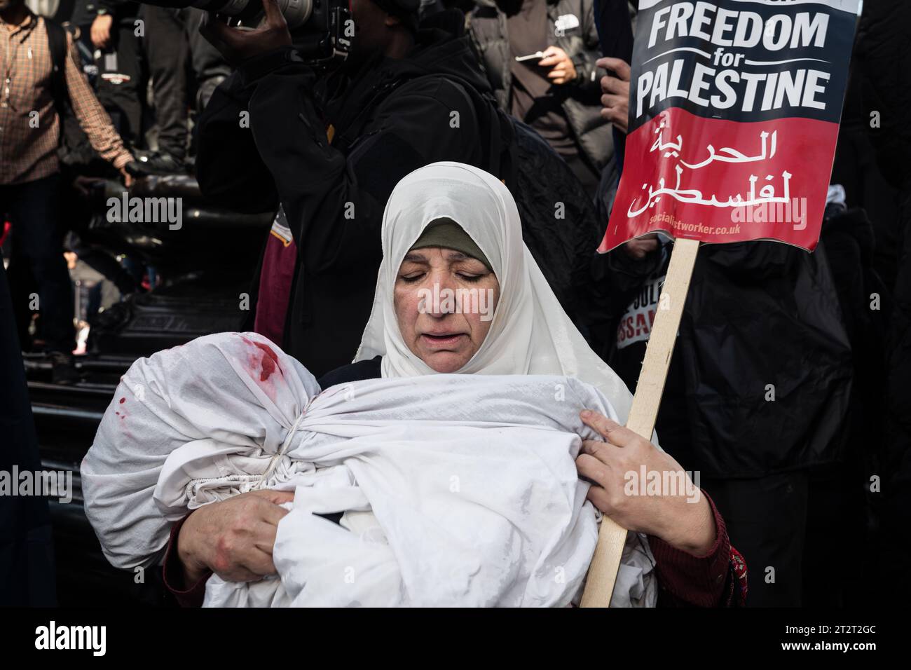 London, UK, October 21, 2023. A woman cradles a fake dead baby during a protest proceeding from Marble Arch to Downing Street, supporting the Palestinian cause in the Hamas-Israel conflict.  (Tennessee Jones - Alamy Live News) Stock Photo